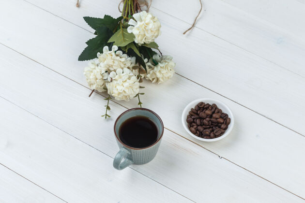 咖啡咖啡在一个杯子里用咖啡豆 花高角度看在木制背景上粗麻布摩卡杯子