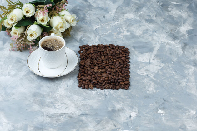 自然一些咖啡与咖啡豆 花在一个蓝色大理石背景上 高角度看杯子早餐大理石咖啡馆