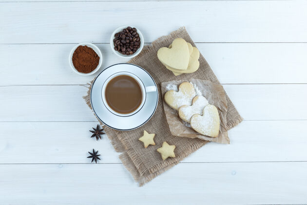 浓缩咖啡一套饼干 香料 咖啡豆 磨碎的咖啡和咖啡在一个木杯和一块布袋背景顶视图卡布奇诺曲奇新鲜