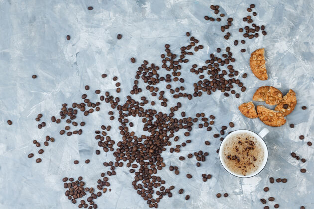顶视图咖啡杯与饼干 咖啡豆在肮脏的灰色背景水平卡布奇诺咕噜早晨