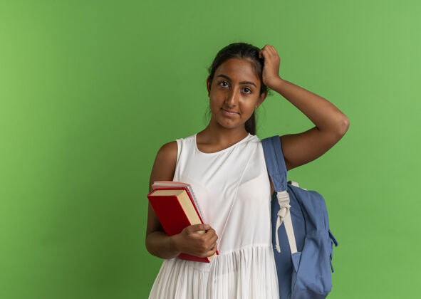 学生年轻的女学生背着书包 手里拿着笔记本 手放在头上女学生手背包