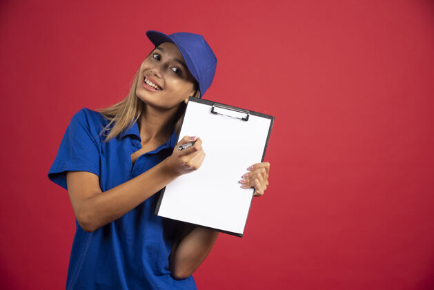 人穿着蓝色制服的年轻女子用铅笔指着剪贴板女性剪贴板指向