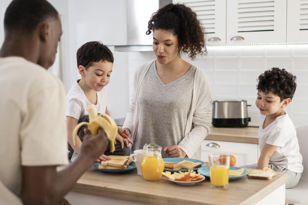 爱快乐的黑人家庭一边吃早餐一边微笑熟悉家庭早餐快乐的人