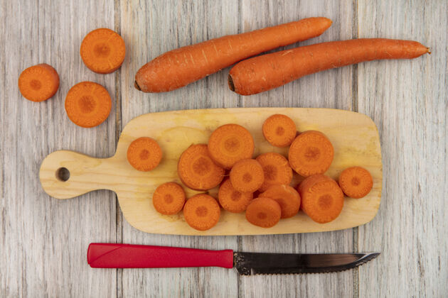美味顶视图美味切碎的胡萝卜在一个木制的厨房板与刀胡萝卜隔离在一个灰色的木制表面新鲜胡萝卜美味