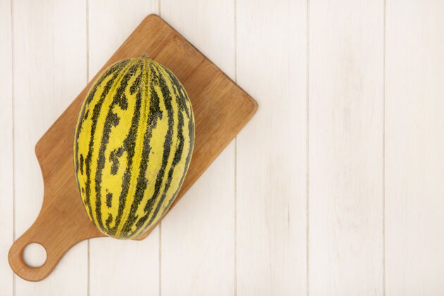 哈密瓜顶视图新鲜的哈密瓜在一个木制厨房板上的白色木质表面与复制空间配料火腿营养