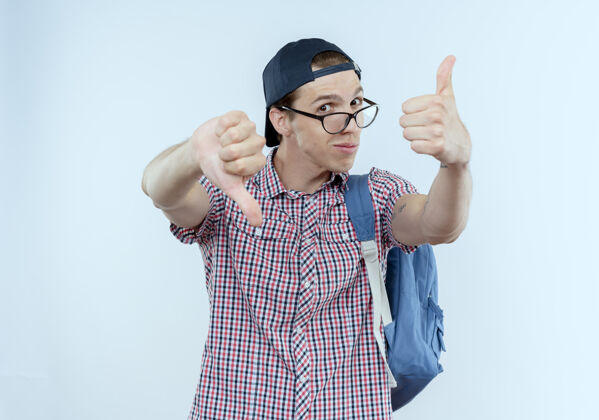 穿给人印象深刻的年轻学生男孩背着背包 戴着眼镜 大拇指上下戴着帽子向上印象青少年