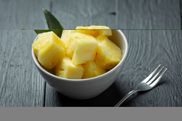 Ananas新鲜的菠萝放在深色的木头表面营养美味黄色