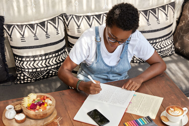 顶部漂亮时尚的黑人女子在笔记本上写书评教育智力笔记
