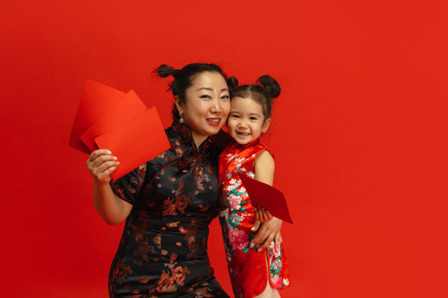 中国新年快乐红色背景上孤立的亚洲母女肖像红色服装祝福
