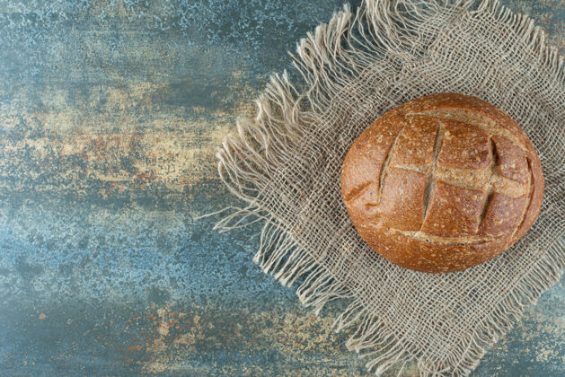 麻布一个全新的棕色面包放在麻布上食品小面包美味