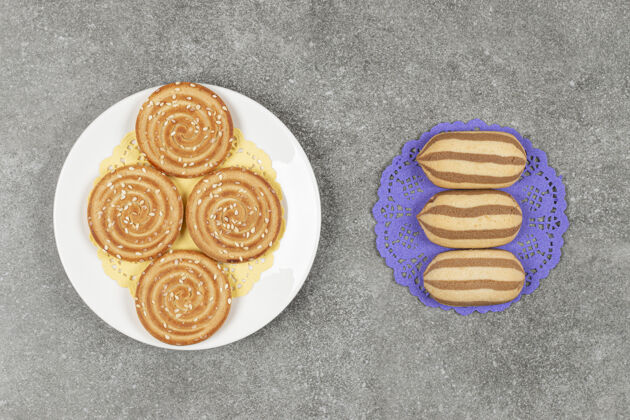 饼干蓝色餐巾上的巧克力条纹饼干和一盘芝麻饼干种子饼干美味