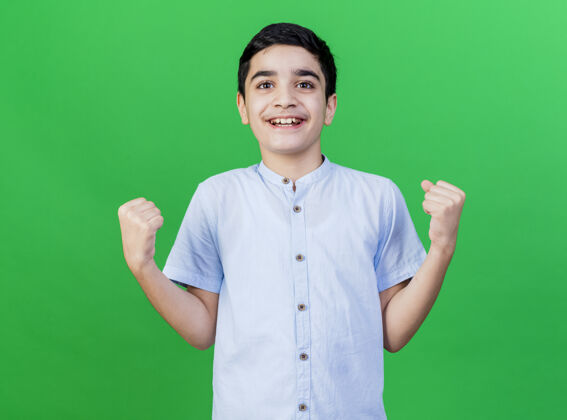 表达快乐的年轻白人男孩在绿墙上做“是”的手势手势年轻男人