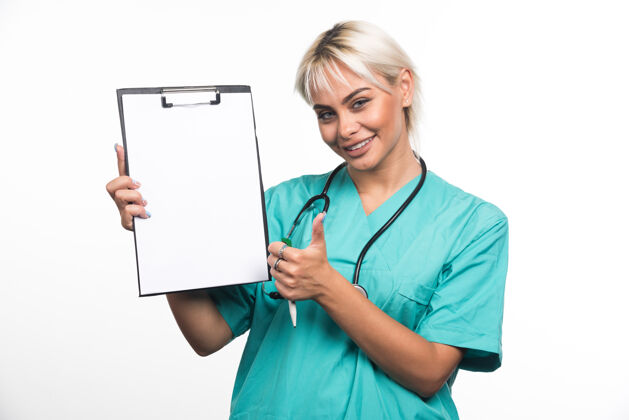 文件夹微笑的女医生拿着剪贴板 在白色的表面上竖起大拇指女性医生站着