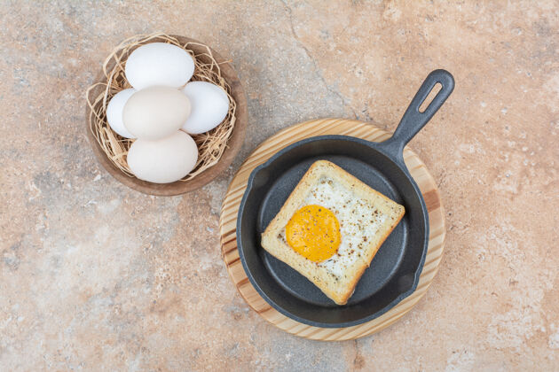 切片黑锅煎蛋面包配一碗鸡蛋生的面包房鸡蛋