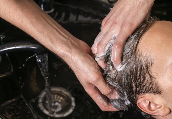 发型师给客户洗头的男人工作风格沙龙