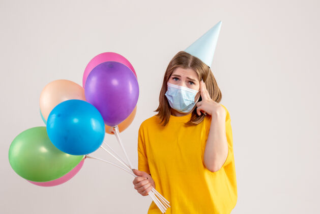 生日戴着白色面具手持彩色气球的年轻女性健康庆祝面具