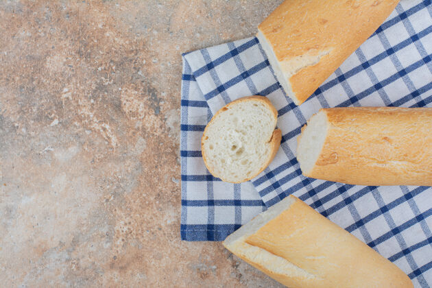 面包房新鲜的法式面包片在条纹桌布上桌布面包皮松脆