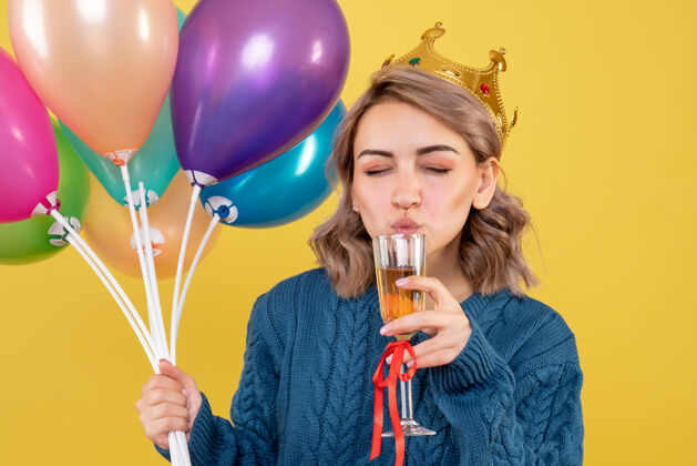 玻璃年轻的女人拿着气球和一杯香槟人聚会乐趣