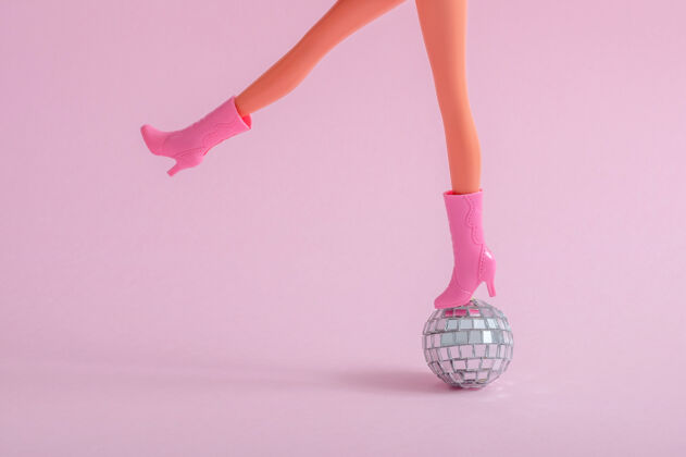 身体在粉红色墙上的小迪斯科球上的娃娃脚游戏小人类