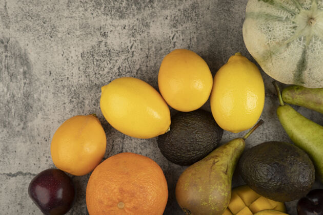 各种一堆新鲜的水果放在大理石表面柿子水果芒果