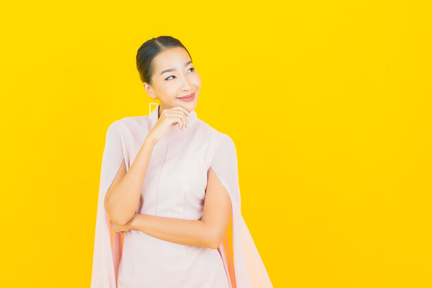 成人画像美丽的亚洲年轻女子微笑着在黄色的墙上有许多动作夏天学生亚洲人