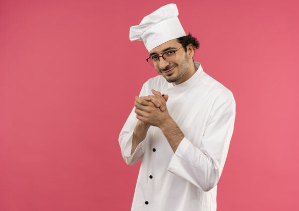 穿着年轻的男厨师穿着厨师制服 戴着一副粉红色的眼镜 脸上孤立地挂着握手的样子 很高兴厨师请握手