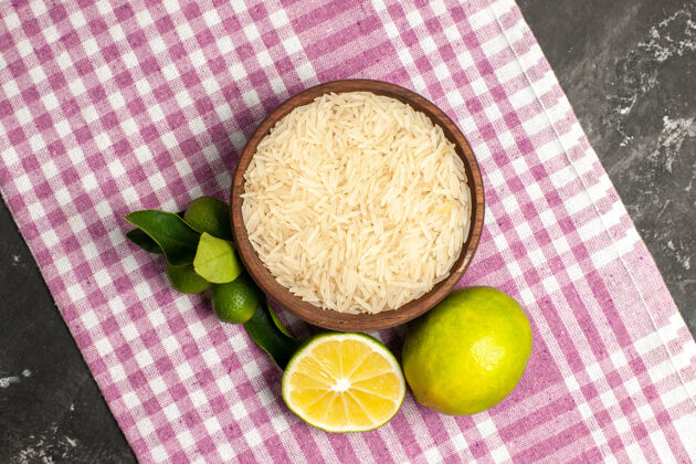营养顶视图生大米与柠檬在黑暗的表面生食水果的颜色饮食顶部观点