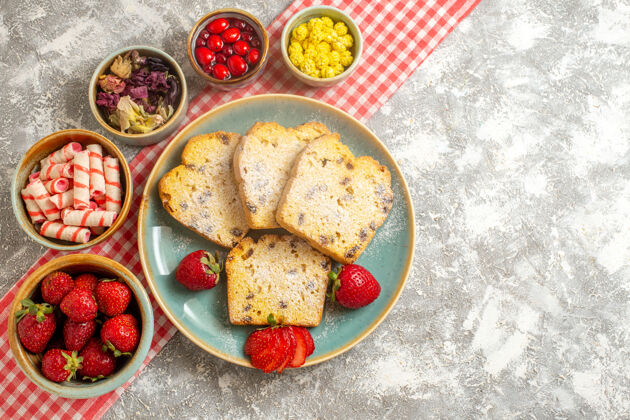 营养品顶视图蛋糕片与新鲜草莓和糖果上轻地板馅饼甜水果派晚餐饮食