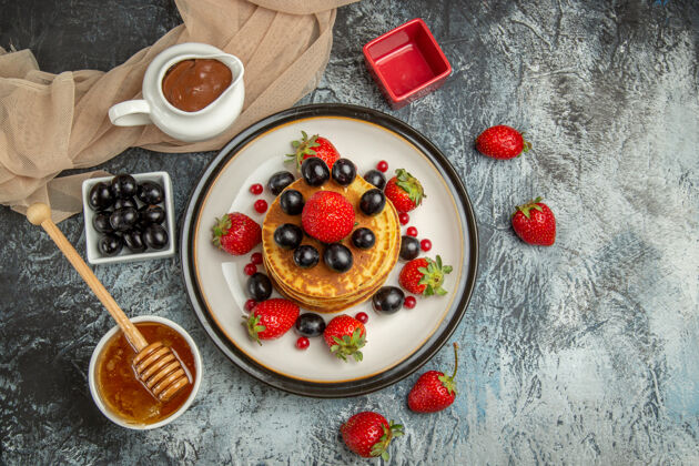 餐俯瞰美味的薄饼与水果和蜂蜜在光表面甜水果蛋糕蛋糕视图光