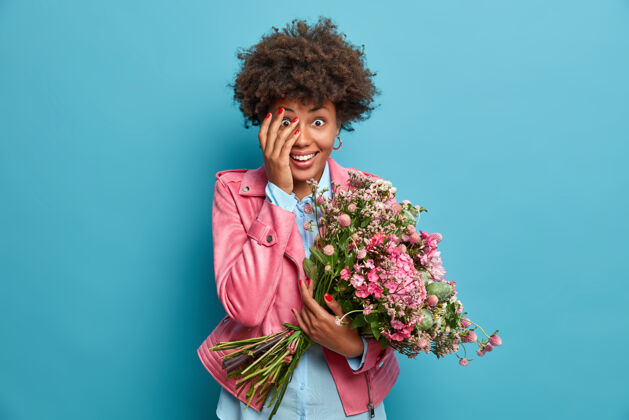 室内快乐搞笑的女人得到意想不到的惊喜 捧着一大束鲜花制造夏天心情