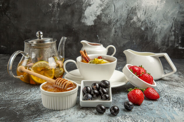 搅拌碗前视一杯茶 橄榄和蜂蜜放在黑暗的表面上早餐食物蜂蜜风景