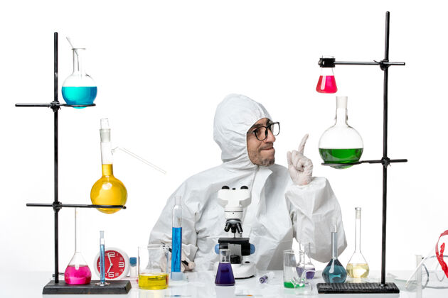 保护正面图穿着特殊防护服的男科学家拿着钢笔坐着实验室实验室实验