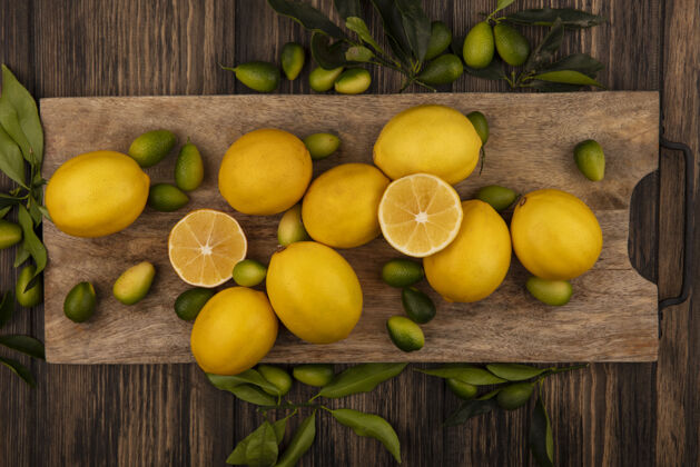 膳食新鲜水果的顶视图 如金盏花和柠檬在木制厨房板上的木制墙壁饮食厨房板