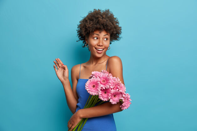 持有快乐优雅的好女人 带着一束粉红色非洲菊 得到鲜花优雅风格女士