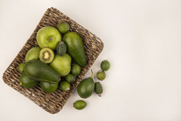 水果新鲜水果的俯视图 如绿色的苹果feijoas鳄梨在柳条托盘上的白色墙壁上复制空间鳄梨托盘顶部