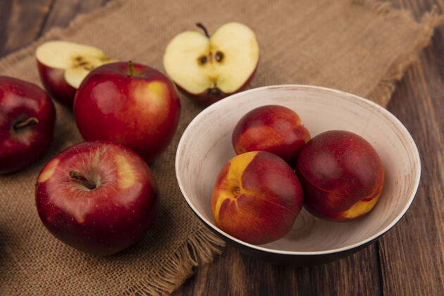 观点顶视图新鲜的桃子放在碗里 苹果被隔离在木墙上的布袋上桃农业饮食