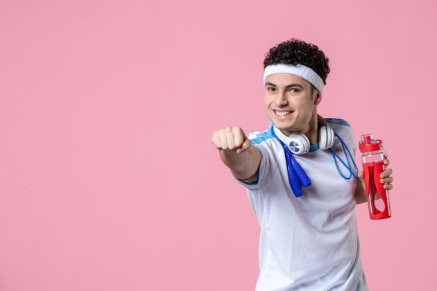 锻炼正面图身穿运动服的年轻男子脖子上系着跳绳粉色的墙壁成功年轻男性粉红色