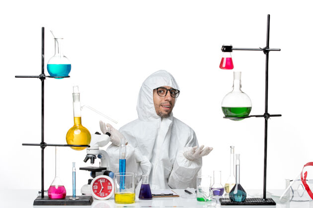 实验室正面图穿着特殊防护服的男科学家围坐在桌子旁 拿着解决方案前面病毒化学