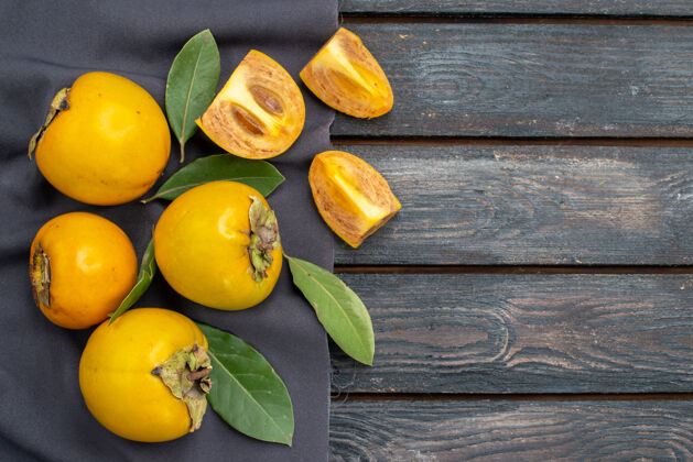 木材俯瞰木质质朴的餐桌上新鲜甜美的柿子 醇香的水果有机黄色收获
