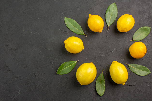 多汁顶视图新鲜的酸柠檬衬在一张深色的桌子上水果柑橘黄色的酸橙背景柑橘顶部