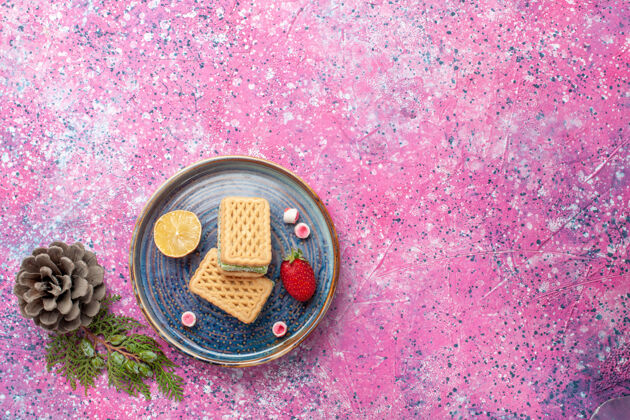 烘焙粉色表面有草莓的美味华夫饼俯视图华夫饼顶视图金属