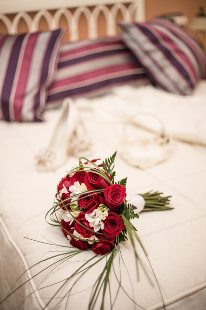 开花床上放着红玫瑰的婚礼花束的垂直镜头束开花花