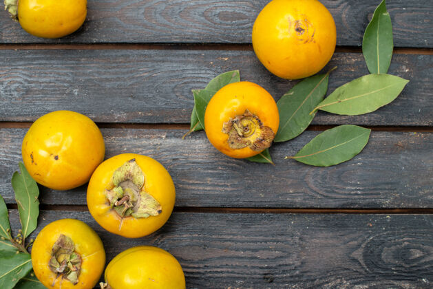 木材顶视图新鲜柿子放在一张木质质朴的桌子上 水果成熟醇厚黄色新鲜柿子食物
