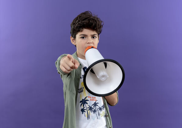 小男孩小男生用喇叭说话 指着紫色的墙上孤立的点尖墙喇叭
