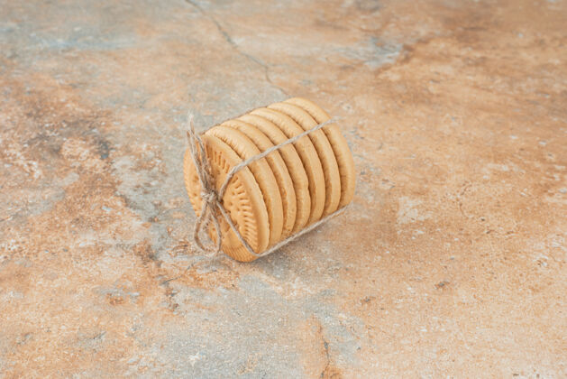 可口甜甜的圆形饼干在大理石背景绳美味食品绳子