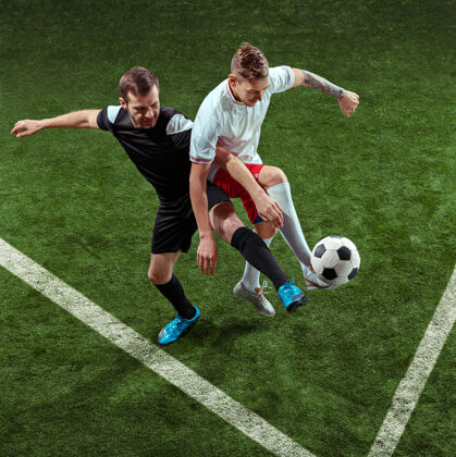 踢足球运动员在绿草背景上抢球活跃足球人