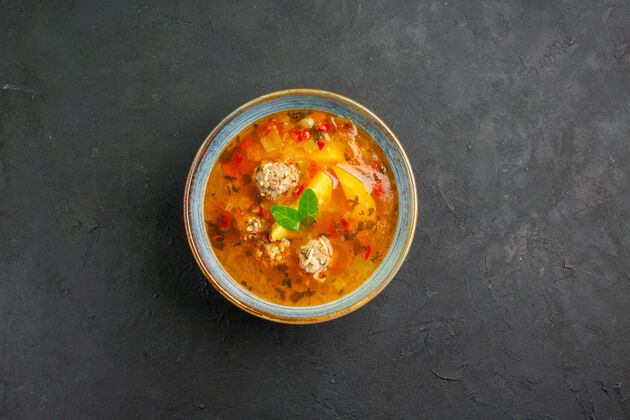 碗俯瞰美味的蔬菜汤和肉和土豆在一个黑暗的餐桌上盘餐食品肉正餐食物