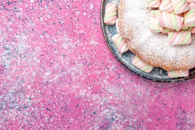 表面粉色表面有甜棉花糖的糖粉蛋糕俯视图饼干含糖粉末