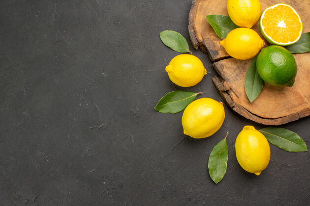 食物顶视图新鲜的酸柠檬和叶子放在深色的水果上 柠檬黄 柑橘黄顶视图水果背景