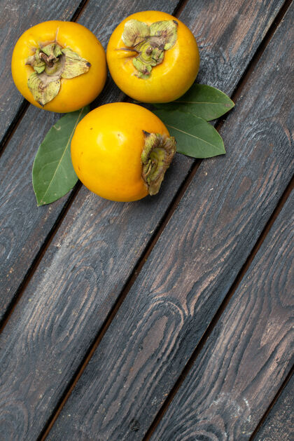 食物顶视图新鲜甜甜的柿子放在木质质朴的餐桌上 水果成熟醇厚乡村木材成熟